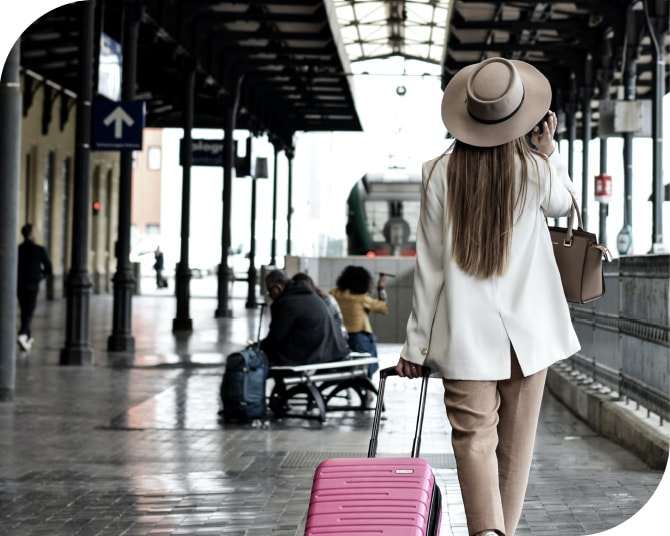 外国の駅でキャリーバッグを持ち、一人旅する女性